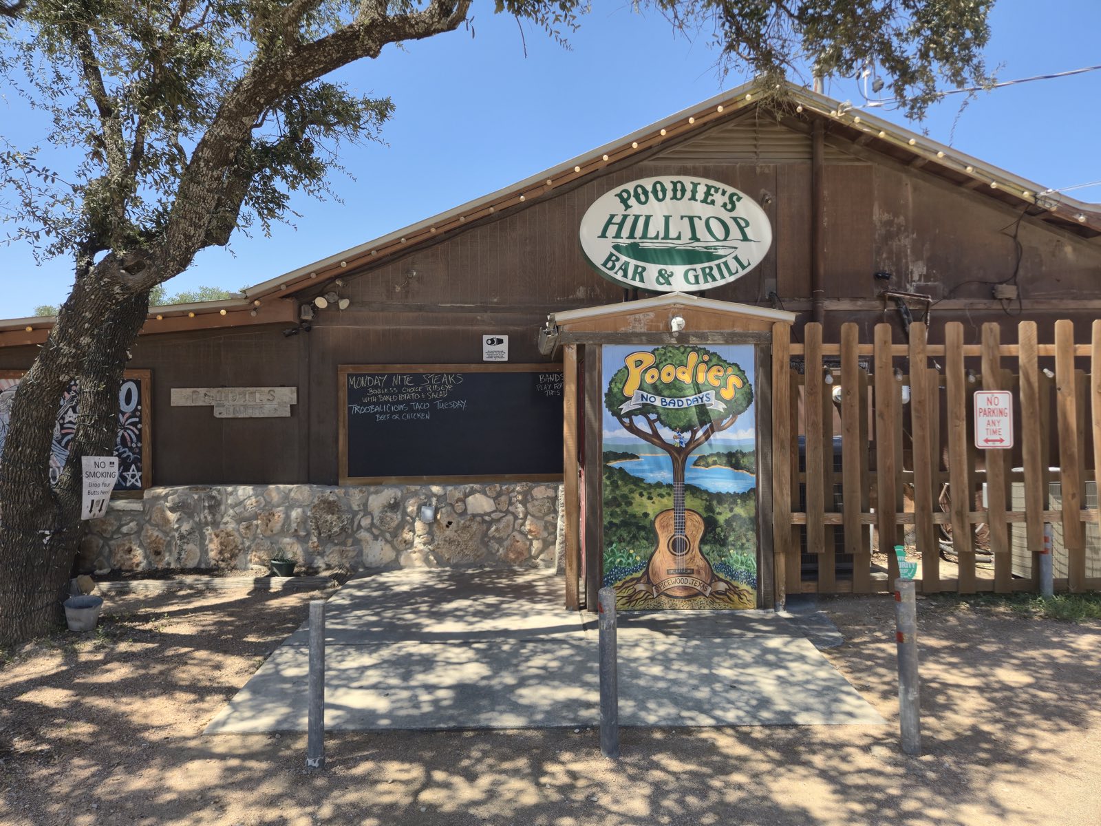 The carved Poodie's Hilltop Bar & Grill sign above the entrance